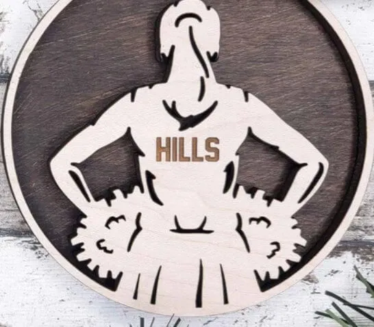 Personalized cheerleading ornament engraved with the team name Hills