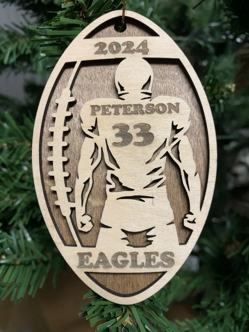 Personalized football ornament engraved with player Peterson, number 33, Eagles team name, and 2024 season